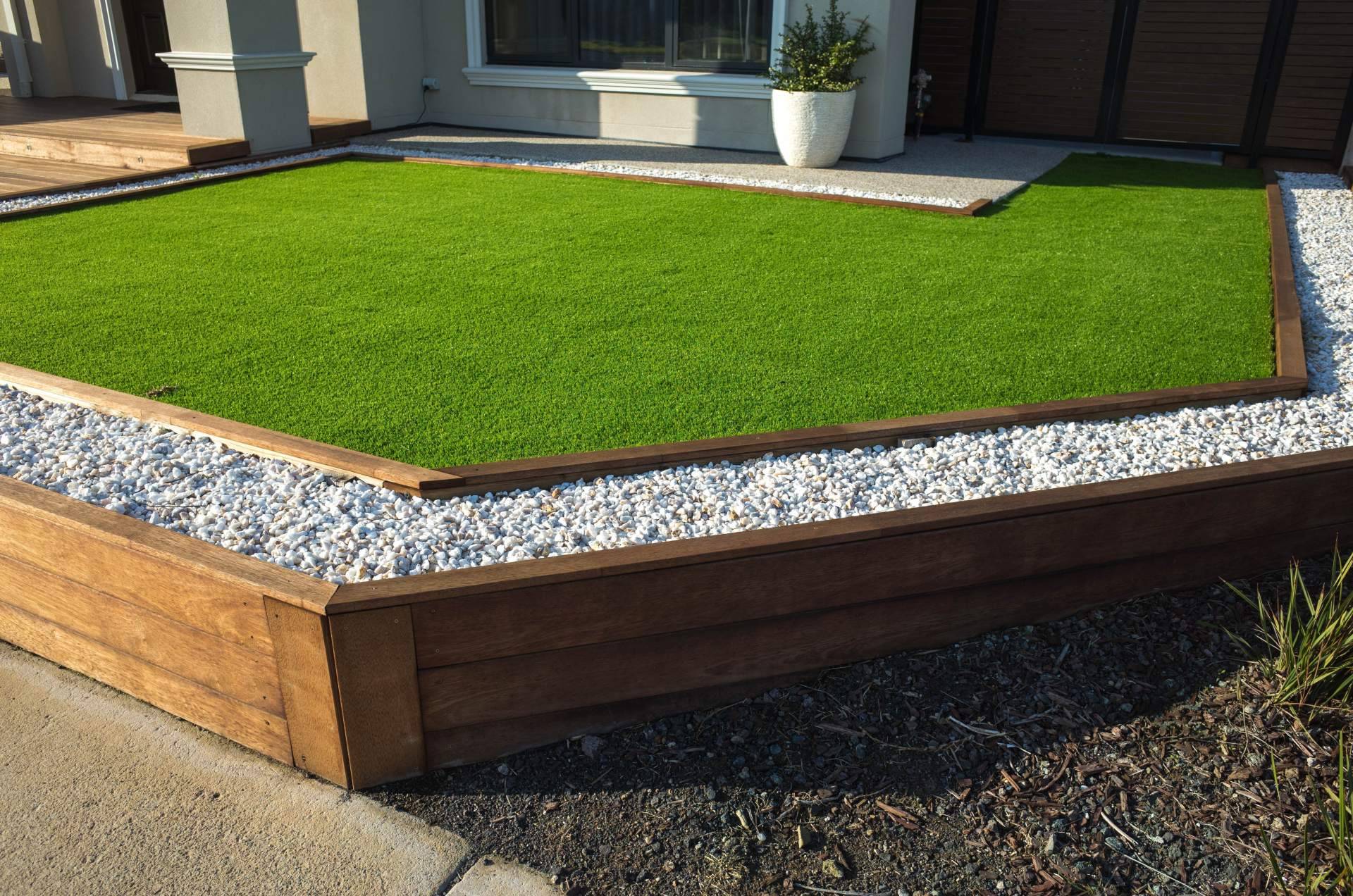 Decorar terrazas con jardines con piedras blancas y césped artificial
